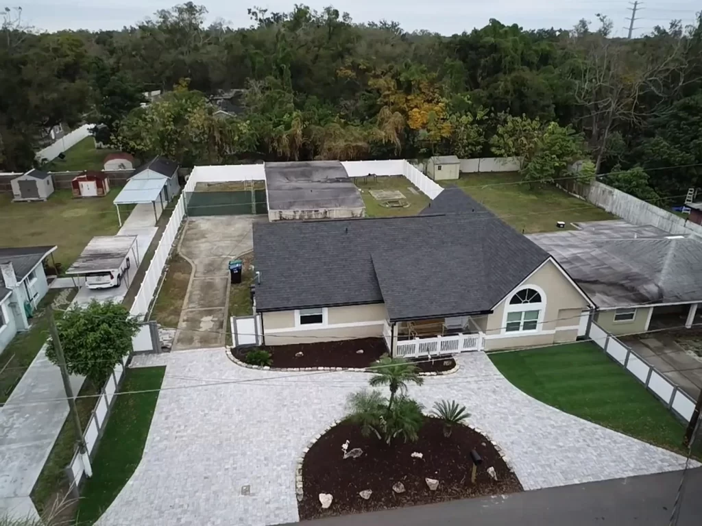 An aerial view of a Longwood Florida home with a landscaped yard, and a new asphalt shingle roof installed by Nine Square Roofing