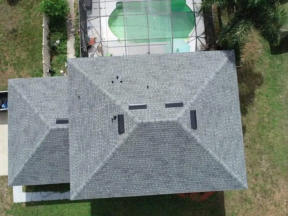 Aerial view of a residential home's gabled roof with grey architectural shingles and complex structure including several valleys and peaks, suitable for a roofing inspection or architectural study.